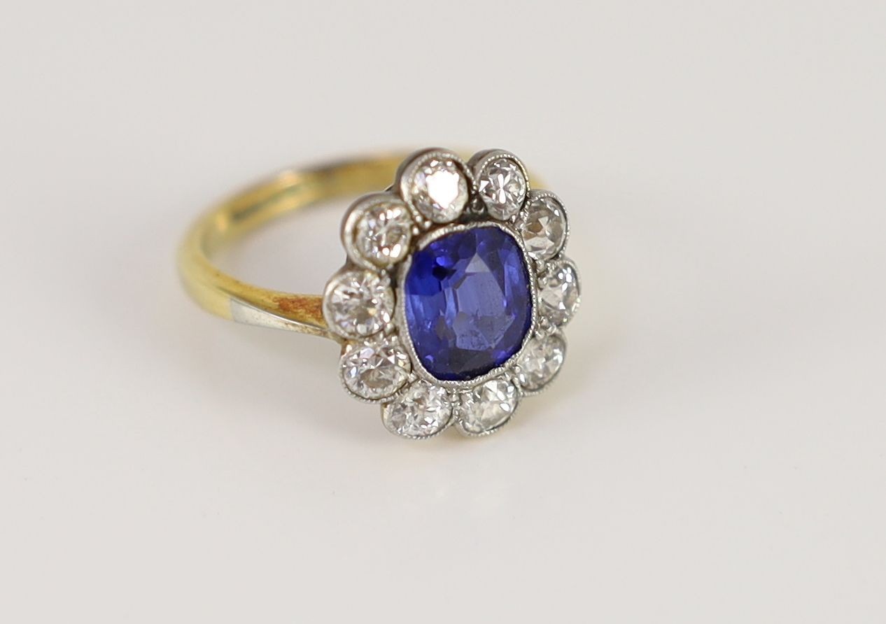 An 18ct gold and platinum, synthetic sapphire and diamond set oval cluster ring